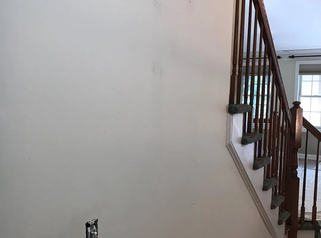 Walls patched and prepped, with floors protected, before painting
