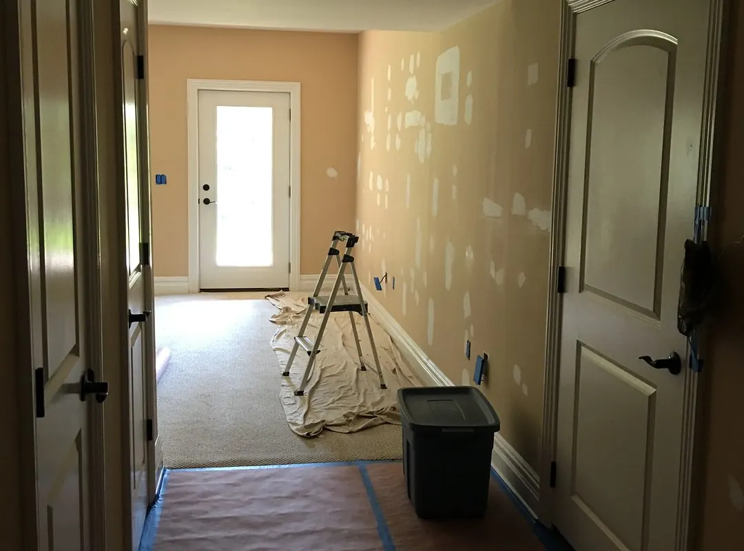 Walls patched and prepped, with floors protected, before painting